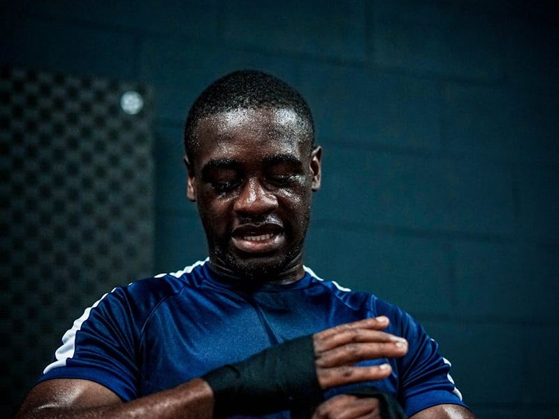 A focused man in athletic wear preparing for a strength movement.