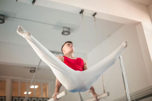 Man performing a controlled strength exercise in a minimalist gym setting.